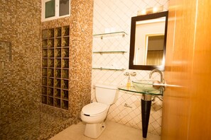 A bathroom with a mosaic tile wall, a glass sink, and a toilet. - Las Olas family Townhome Apartments (Playa del Carmen)