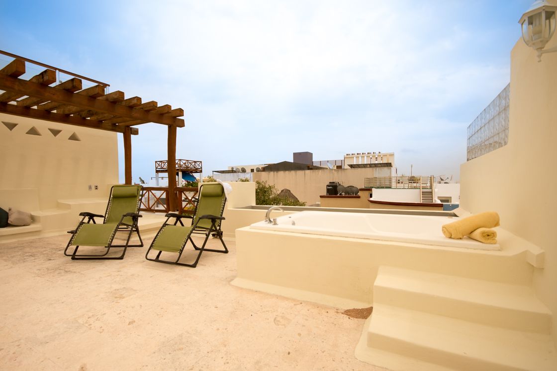 A rooftop terrace with a sun lounger, a small pool, and a pergola.