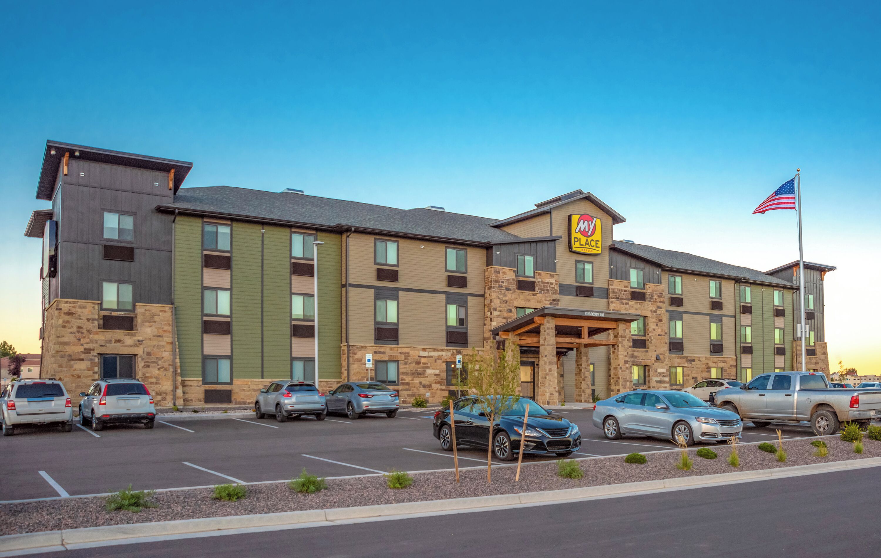 A multi-story hotel with a prominent 'Marriott' sign, a parking lot with several cars, and an American flag.