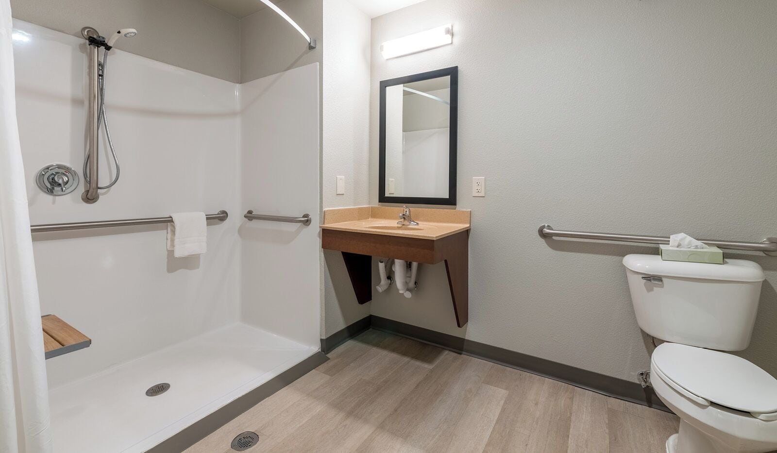 A modern bathroom with a shower, sink, and toilet.