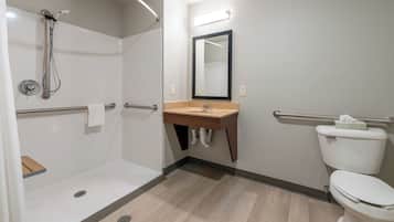 A modern bathroom with a shower, sink, and toilet.