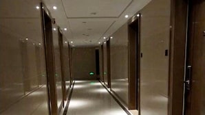 A long, narrow hallway with a shiny floor and doors on both sides. - Goodview Apartment Hotel (Changsha)