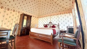 A room with a wooden bed, a wardrobe, and a desk with chairs. - Hotel Green Haveli (Pushkar)