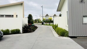 A residential street with modern houses, a clear sky, and a parked car. - Lovely Sunny Home Sweet Home (Christchurch)