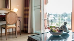 A room with a dining table, a chair, a bowl of snacks, and a decorative item. - Sheik Istana Hotel Chiangmai  (Chiang Mai)