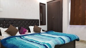 Een slaapkamer met een bed, een donker houten hoofdbord, een grote spiegel en een bruine deur.