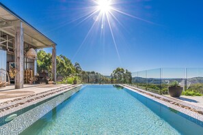 Alberca al aire libre y camastros 