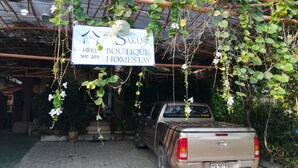 Placa de um sobrado aconchegante com um veículo estacionado sob uma cobertura.