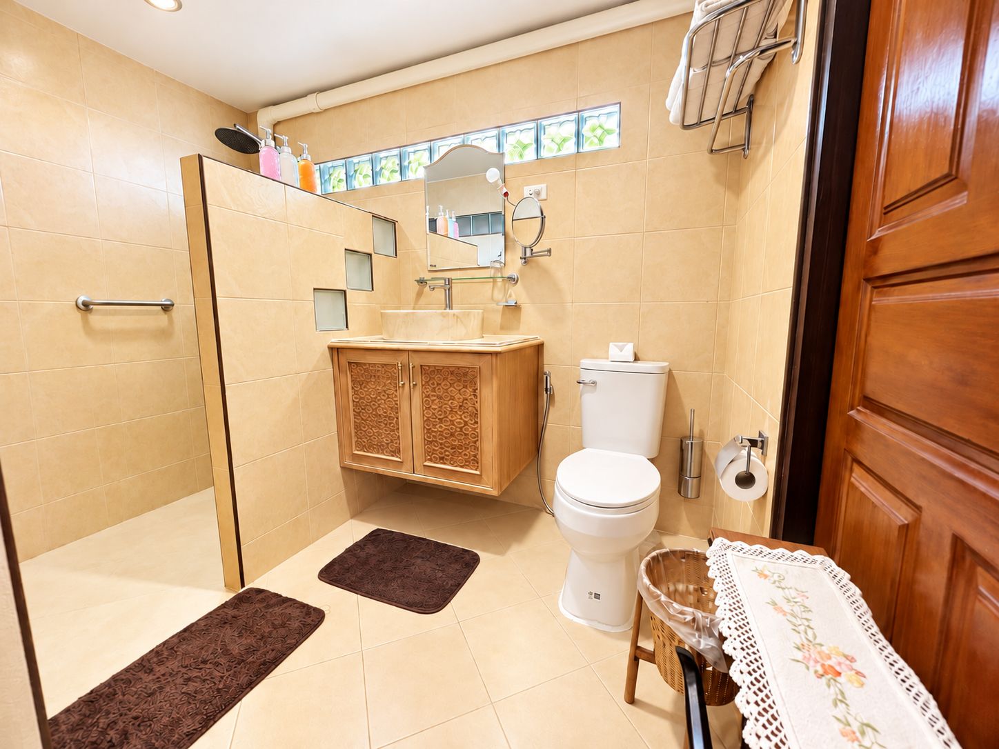 Un baño con ducha, inodoro, lavabo y un armario de madera.