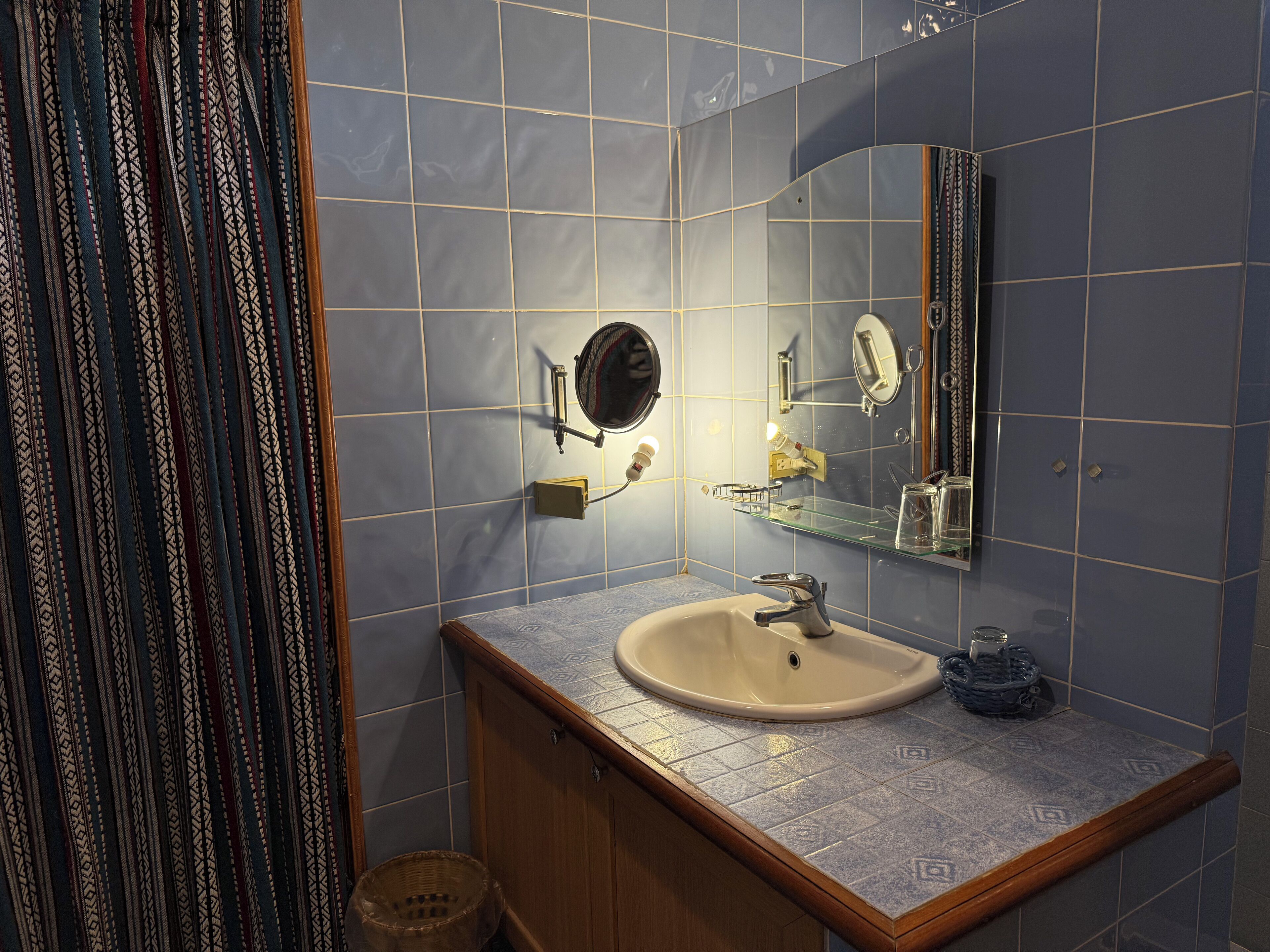 A bathroom with a sink, mirror, and towel rack.