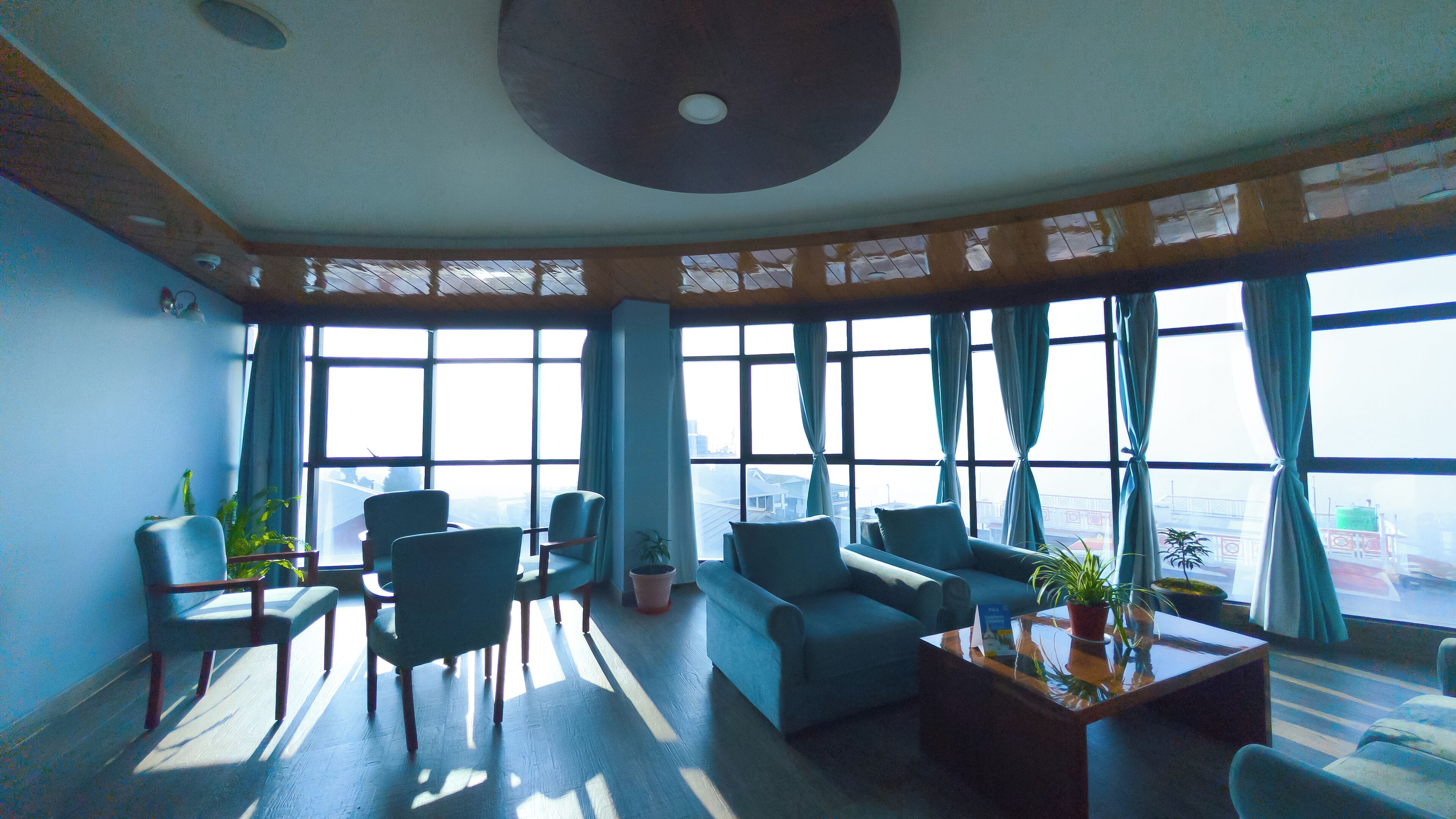 A spacious lounge area with large windows, comfortable seating, and a central coffee table.