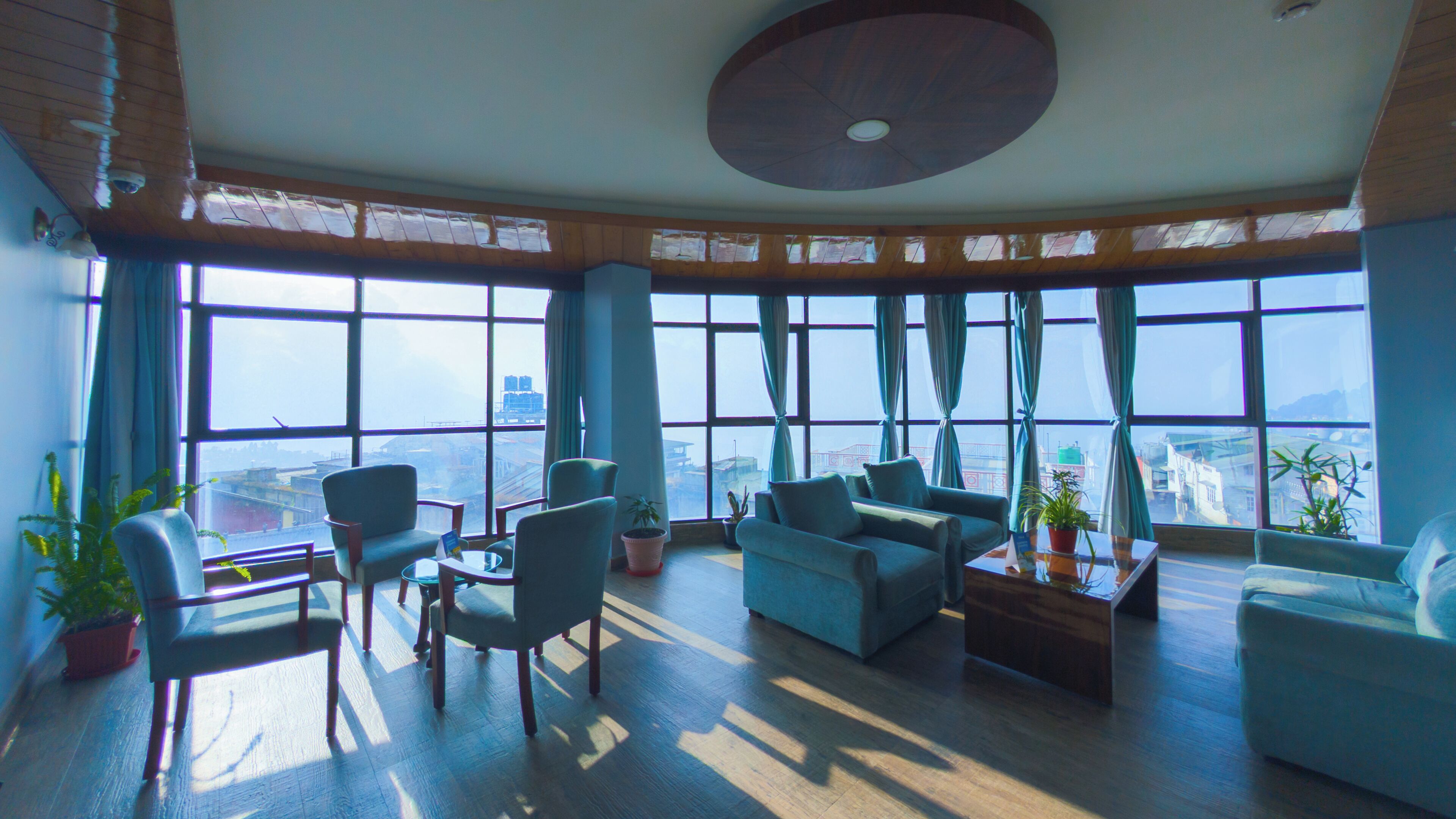 A spacious room with large windows, a curved ceiling, and modern furniture.