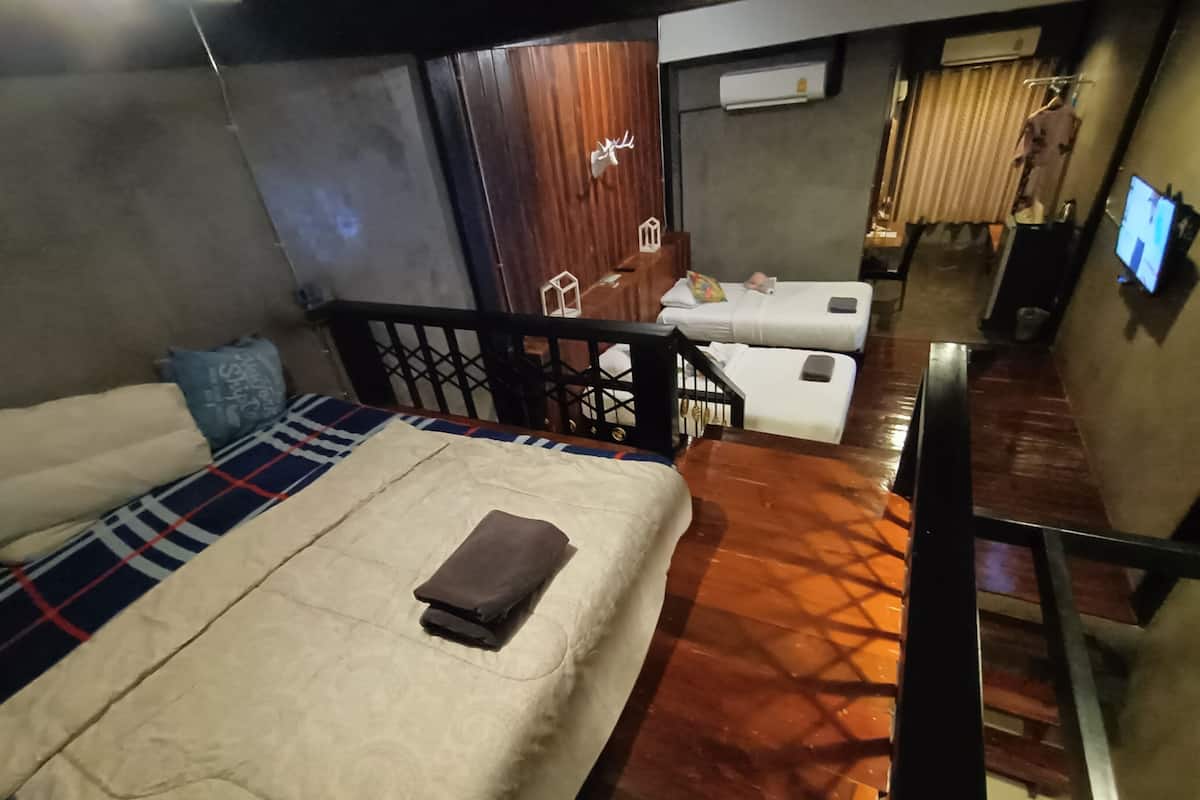 Habitación de hotel con cama, una mesita, una silla, televisión y ventana con cortinas.