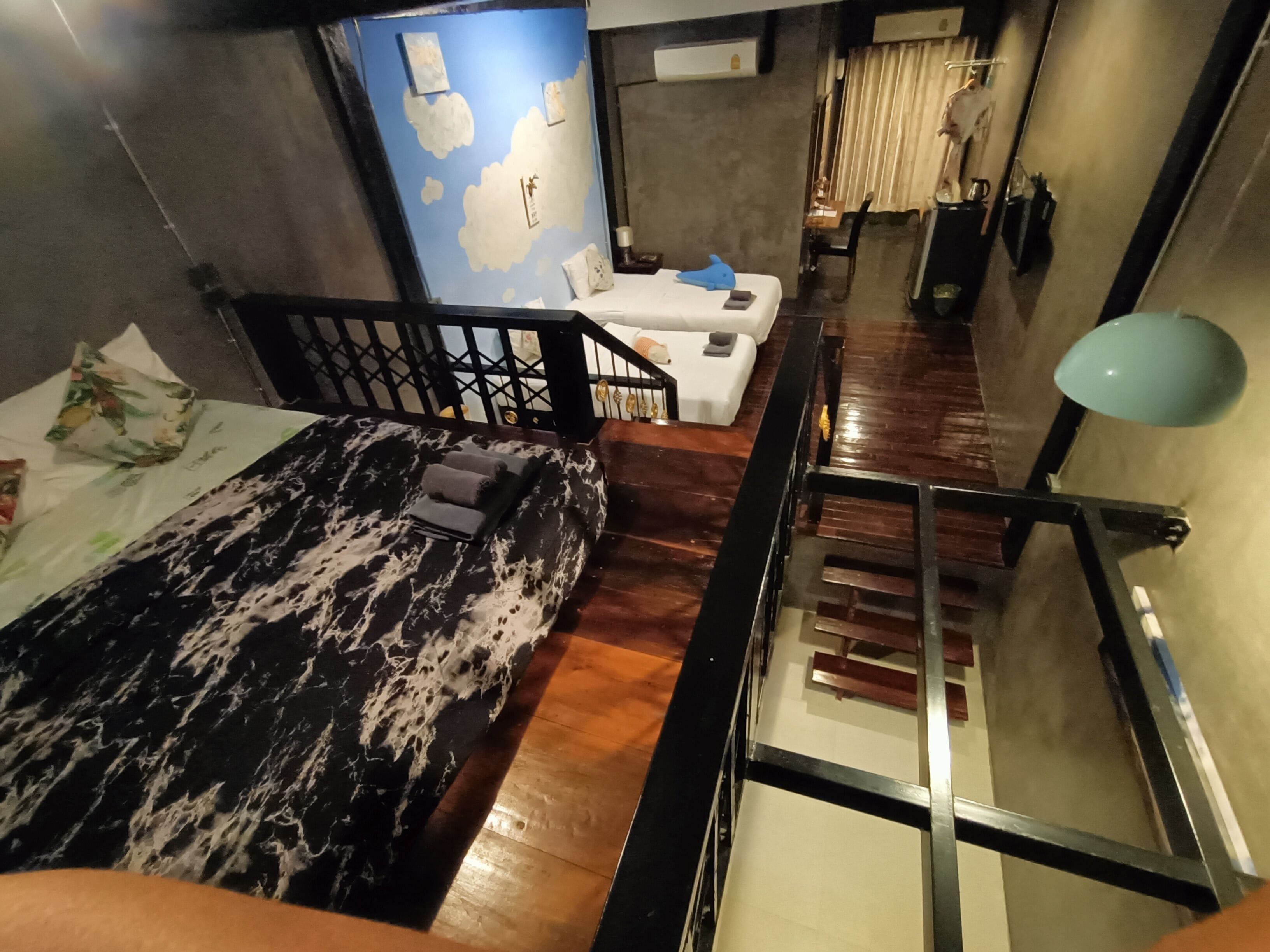 Una sala moderna con un sofá estampado en mármol, una escalera y vistas de la ciudad.