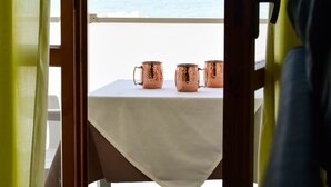 A table with a white tablecloth and three copper mugs on a balcony overlooking the sea. - Hotel Embassy Pesaro (Pesaro)