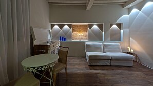 A modern living room with a sofa, a dining table, and a kitchen area. - SestoSenso Suites (Campiglia Marittima)