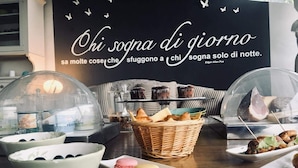 A table with pastries, macarons, and a basket of bread. - SestoSenso Suites (Campiglia Marittima)