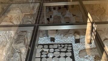An archaeological exhibit with stone artifacts and a tiled floor.