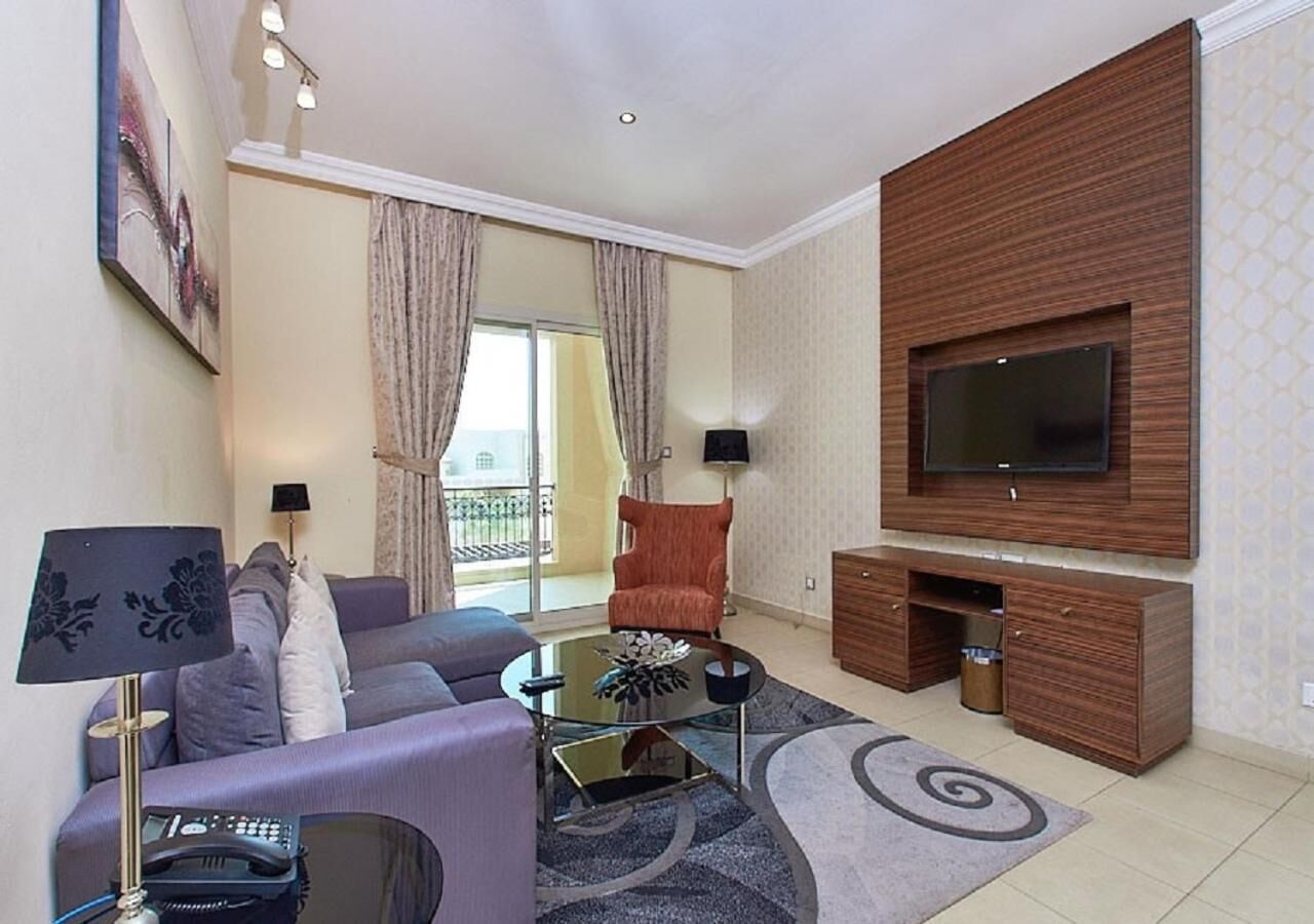 A modern living room with a sofa, coffee table, and TV stand.