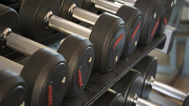 A rack of dumbbells with weight markings. - Mughal Suites (Ras Al Khaimah)