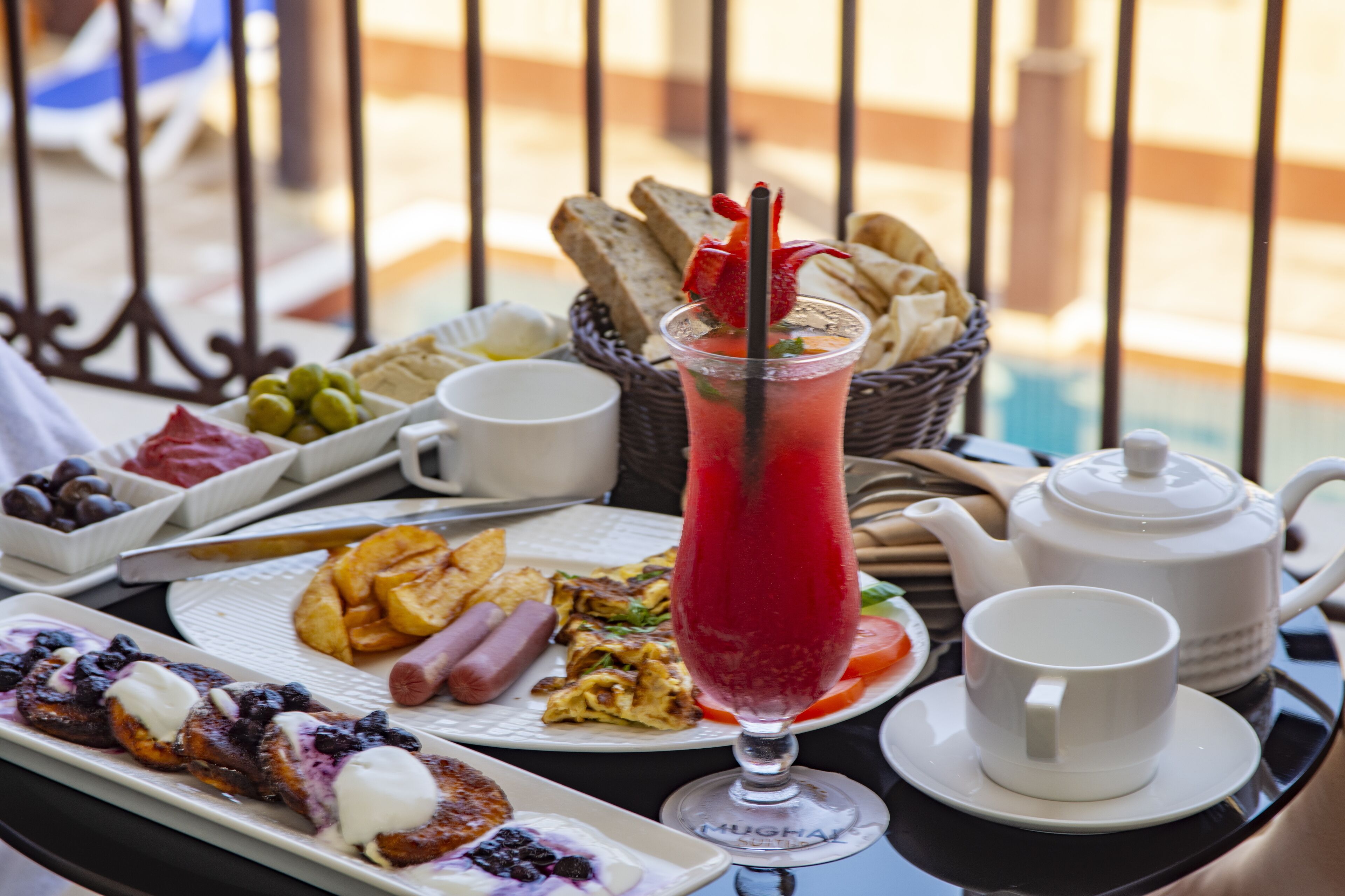 Une table de petit-déjeuner avec divers aliments, une théière et une tasse.