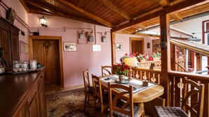 A wooden dining area with a table set for four, surrounded by wooden chairs. - La Teo Pensiune si Pivnita (Sighisoara)