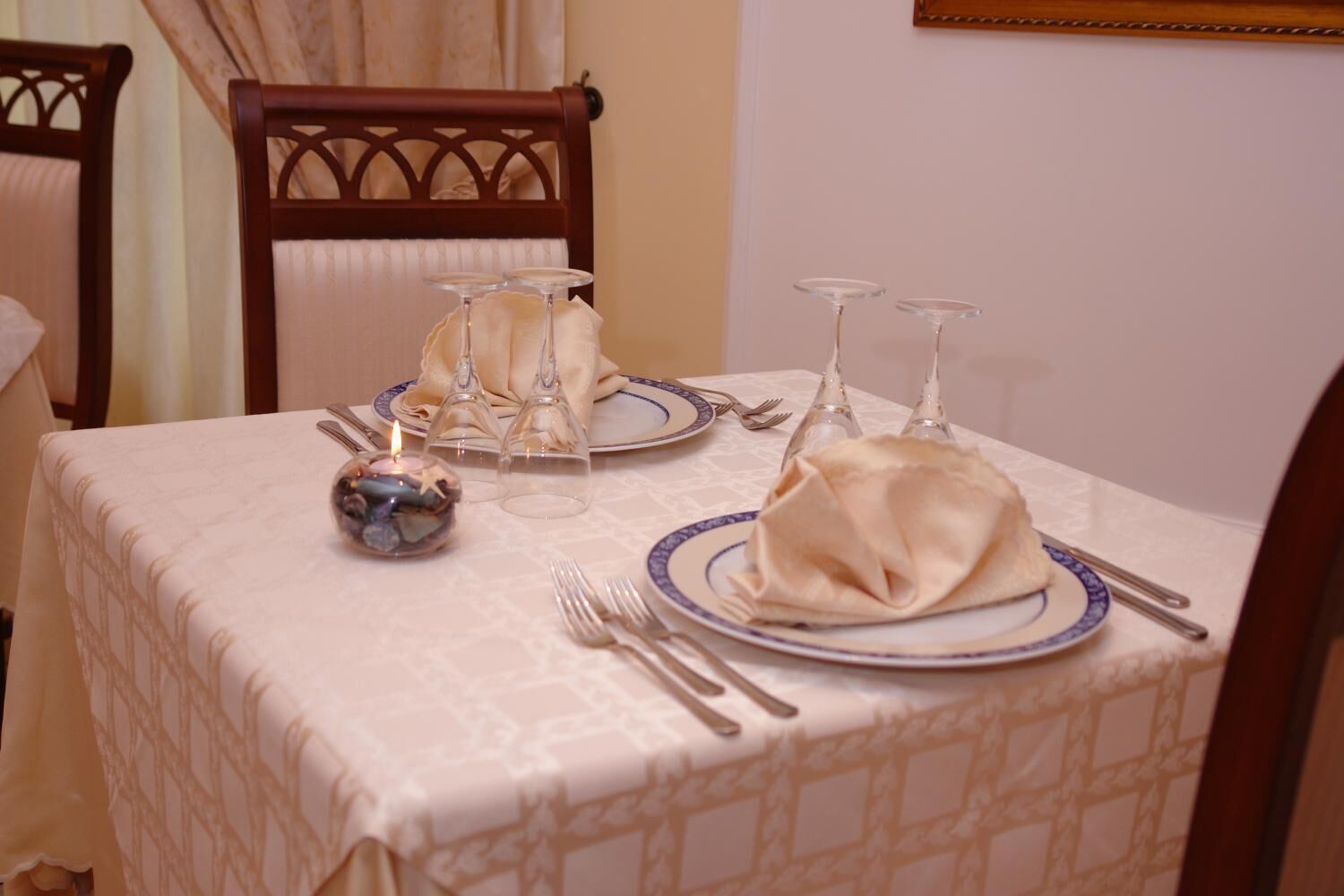 A table set for dining with a candle, plates, and cutlery.