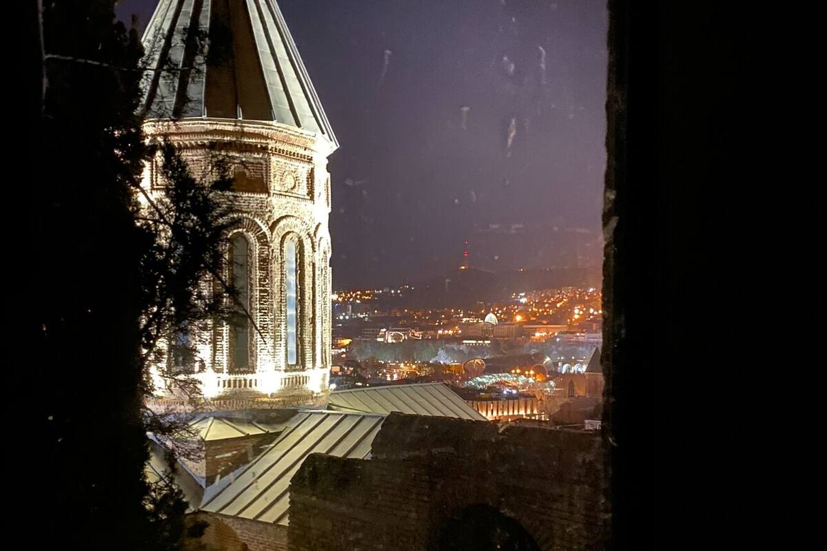 A historic building with a prominent tower and arched windows, viewed from a snowy foreground.