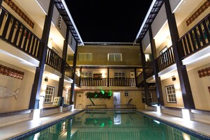 Una piscina interior de varios niveles con una piscina central, rodeada de balcones con barandillas.