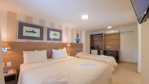 A hotel room with two beds, a desk, a chair, a TV, and a wardrobe. - Pousada da Prainha (Arraial do Cabo)