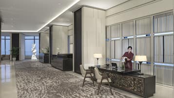 Eine moderne Hotelhalle mit Empfangstresen, Sitzgelegenheiten und Dekorationselementen.