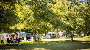 A campsite with tents and camping chairs.