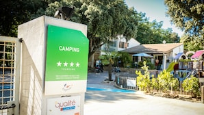 A green sign with "CAMPING" and "TOURISME" text, a "Quality" label, and a "2012" date.