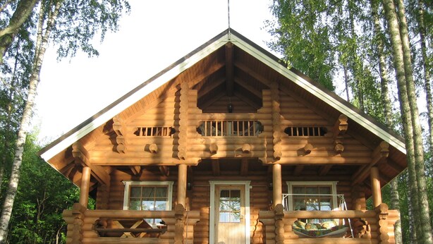 A log cabin with a porch, two windows, and a chimney. - Raikala (Savonlinna)