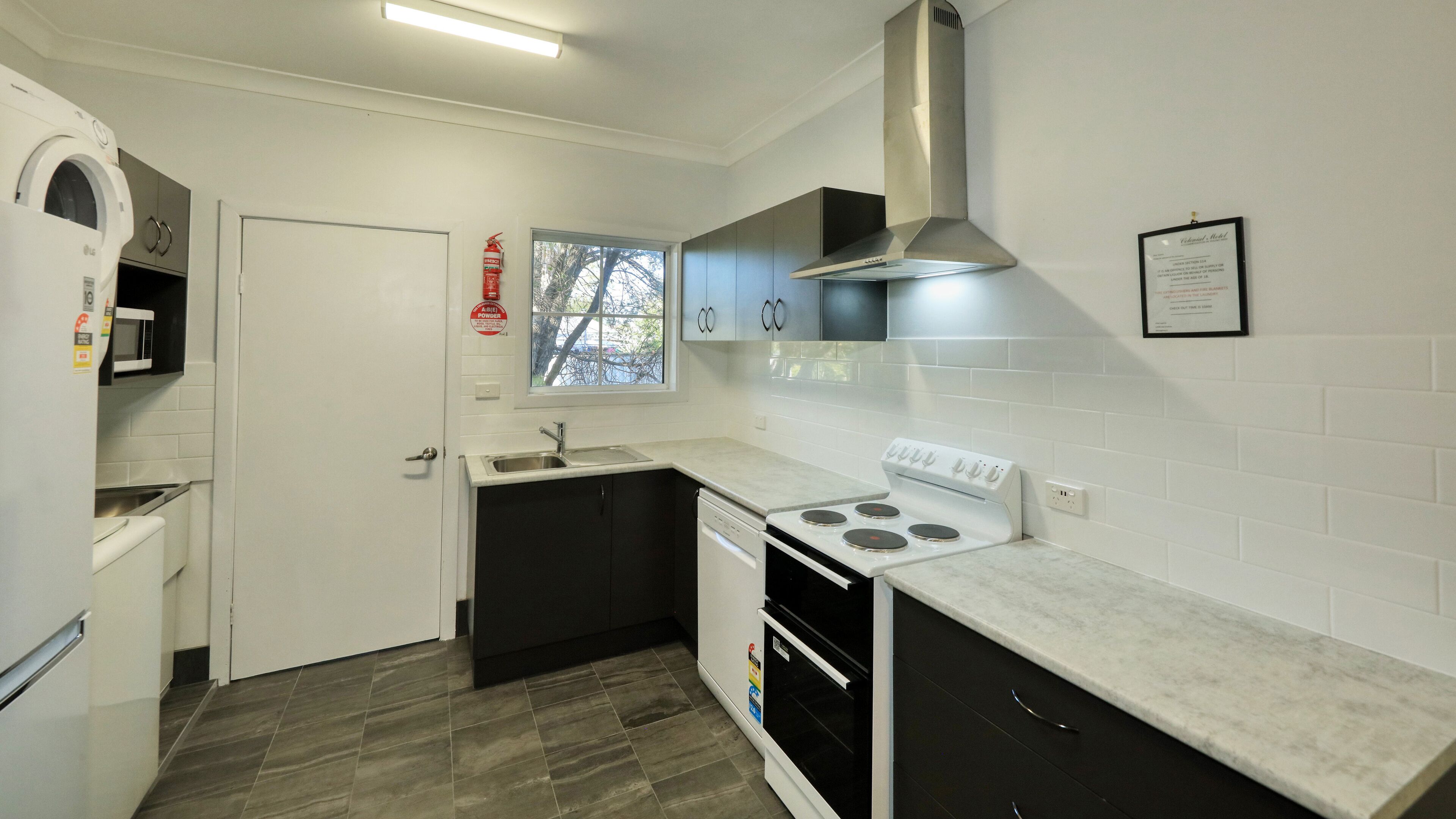 A compact kitchen with a stove, sink, and microwave.