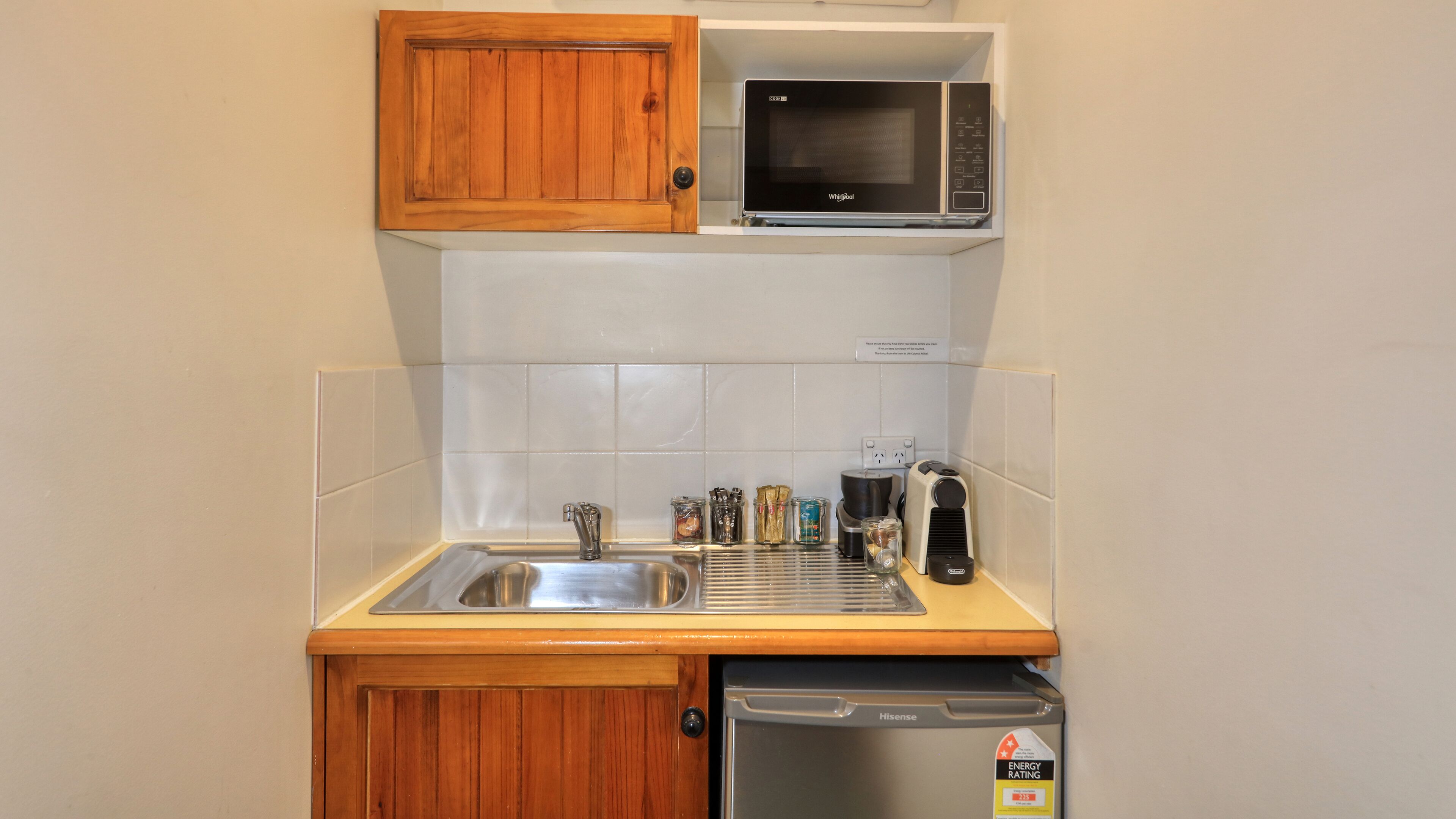 A compact kitchen with a sink, a microwave, a toaster, and a dishwasher.