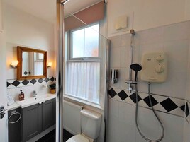 A modern bathroom with a shower, toilet, and sink.