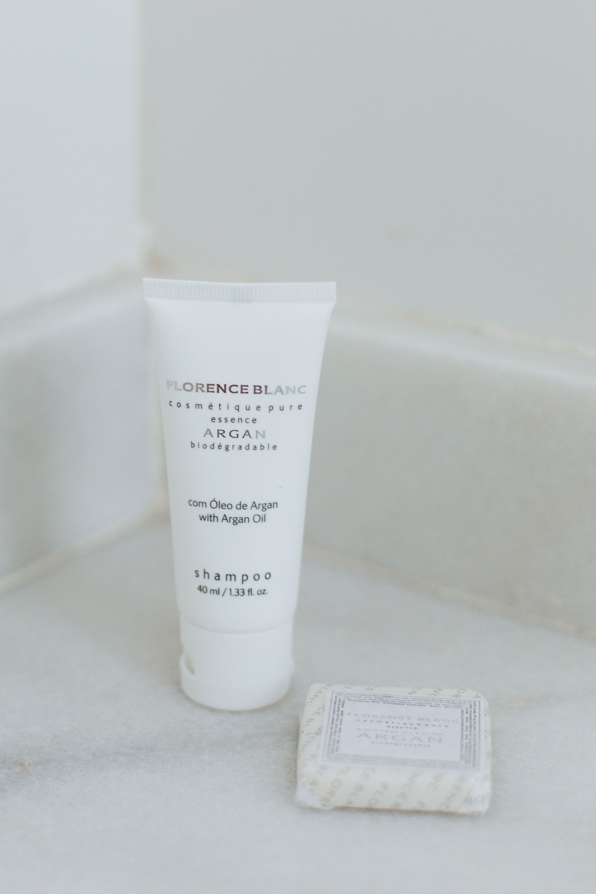 Een fles Florence Blanc Argan shampoo en een zeepstang ernaast.