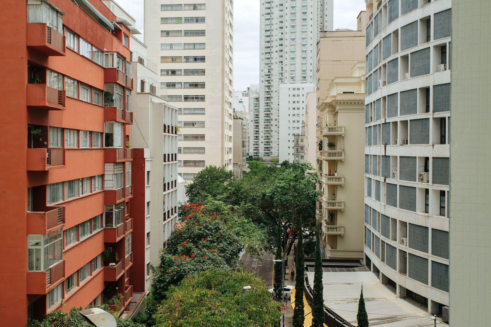 A multi-story residential building with balconies and a narrow street between the buildings.