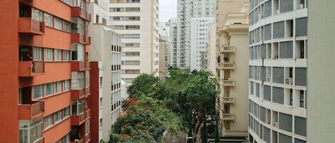 A multi-story residential building with balconies and a narrow street between the buildings.