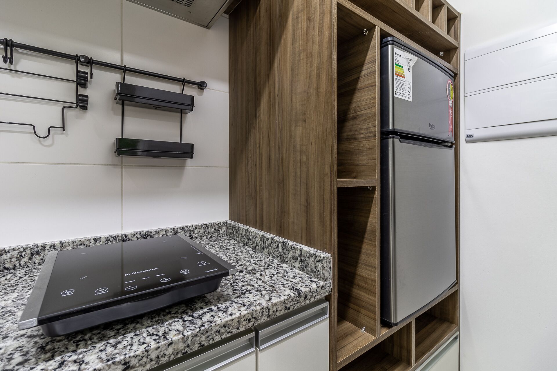 Una cucina con piano cottura integrato, frigorifero e mobili in legno.