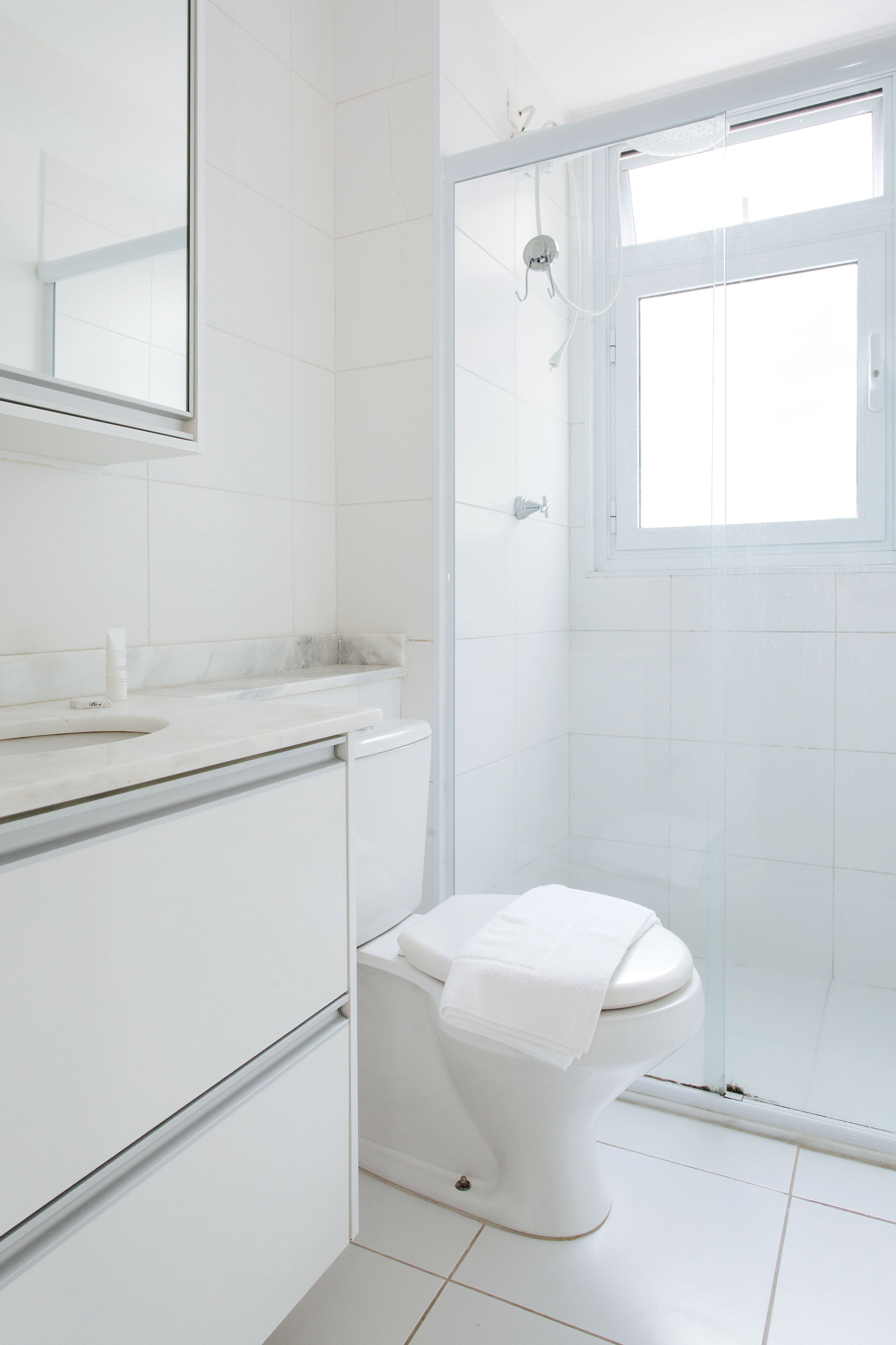 A modern bathroom with a toilet, sink, and shower area.