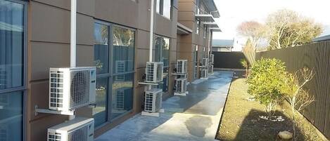 Un edificio moderno con múltiples unidades de aire acondicionado instaladas en las paredes exteriores.