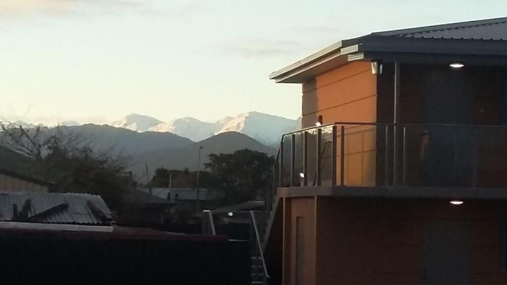 A building with a balcony overlooking a mountainous landscape.