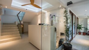 A modern interior with a staircase, a reception desk, and potted plants. - Signature Boracay Blue (Boracay Island)