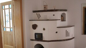 A corner room with a wooden door, a built-in fireplace, and a small shelf with decorative items. - Ferienwohnung by Josef Lanzinger (Bad Vigaun)