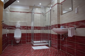 A modern bathroom with a glass-enclosed shower, a white toilet, and a sink with a mirror above it. - Hotel Ostende (Chocerady)