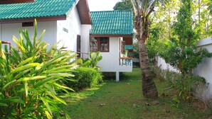 A white building with a green roof and a small balcony. - Surin House (Choeng Thale)