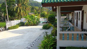 A building with a balcony, a pool, and surrounding greenery. - Surin House (Choeng Thale)