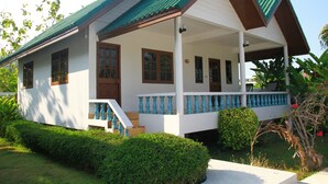 A two-story house with a green roof, white exterior, and a covered porch with blue railings. - Surin House (Choeng Thale)